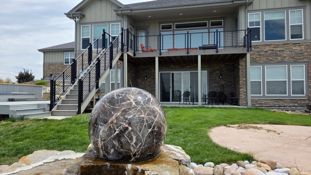 Black metal balcony railing on a gray house