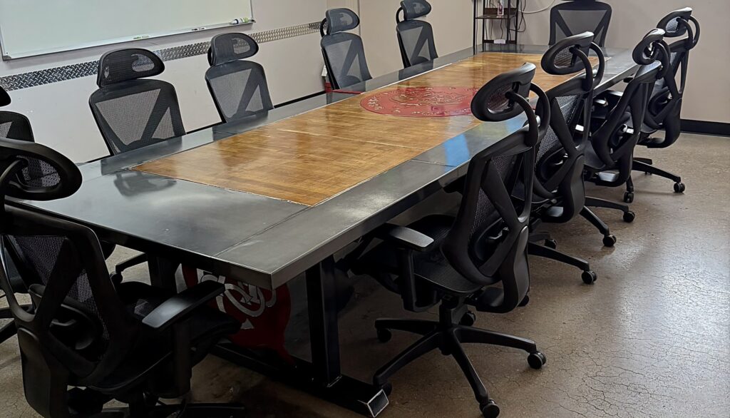Wood-and-metal conference table with black chairs