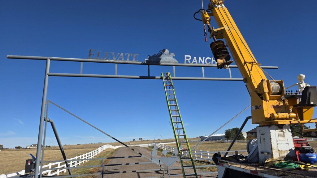 Crane installing an overhead Ranchland Rustics sign